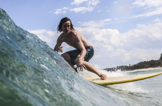 Surfer catching a great wave at Coffs Harbour best beach near Diggers Beach Accommodation