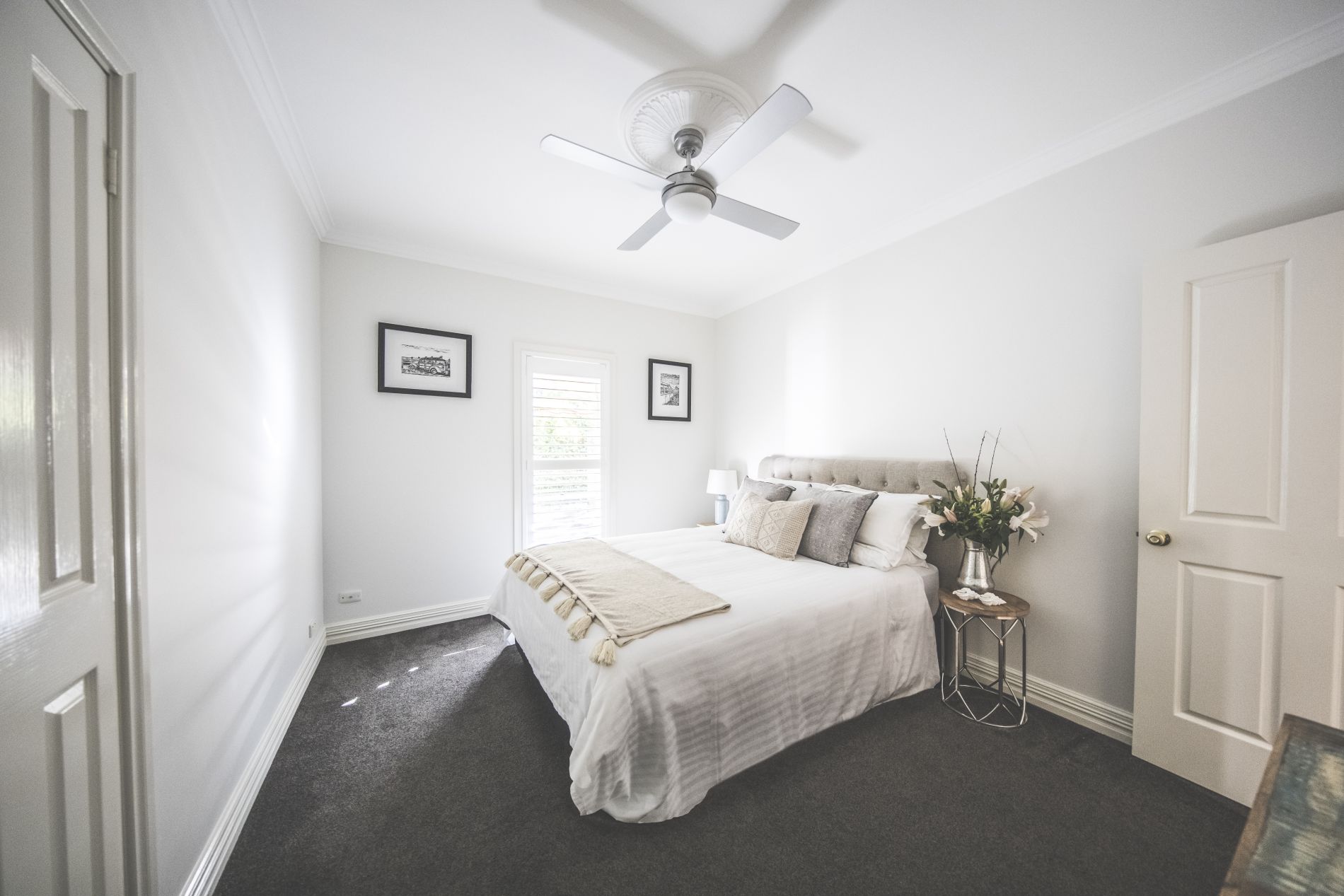 Soft tones and linens second bedroom queen size bed with cushions and fresh flowers